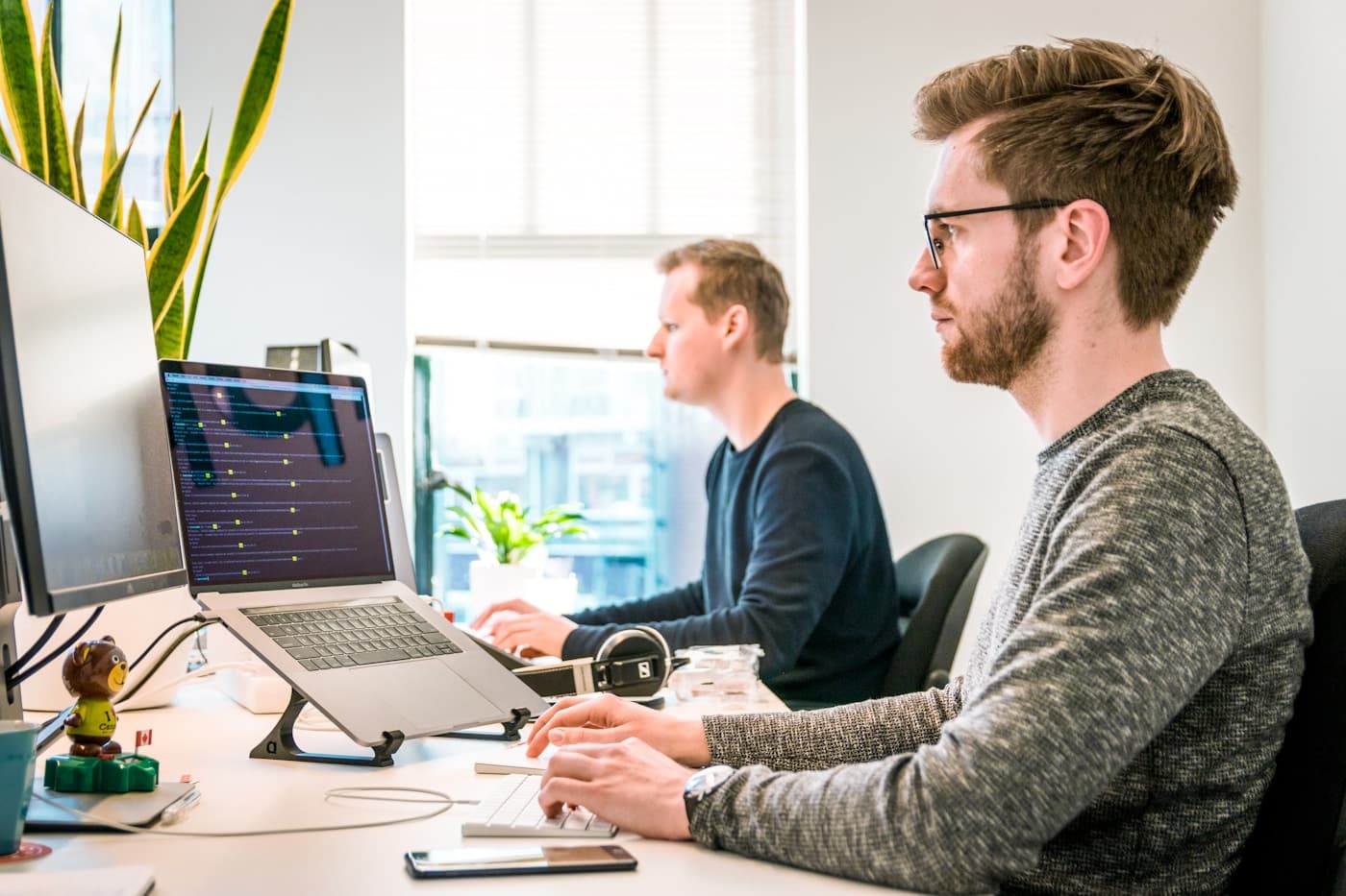 Web team working at a shared desk with code and website screens