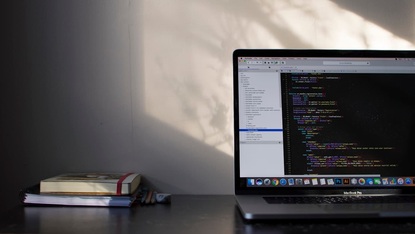 Laptop showing a code editor and notebooks representing website build depth